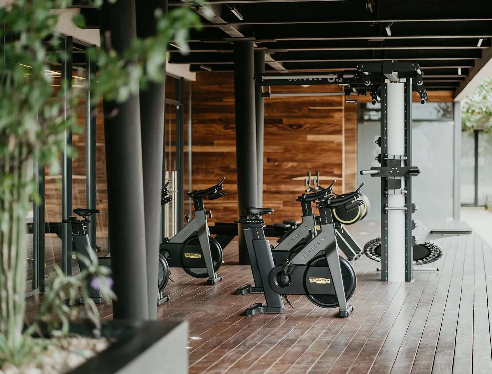 Covered fitness area with spin bikes and strength equipment at The Club at Solaz.
