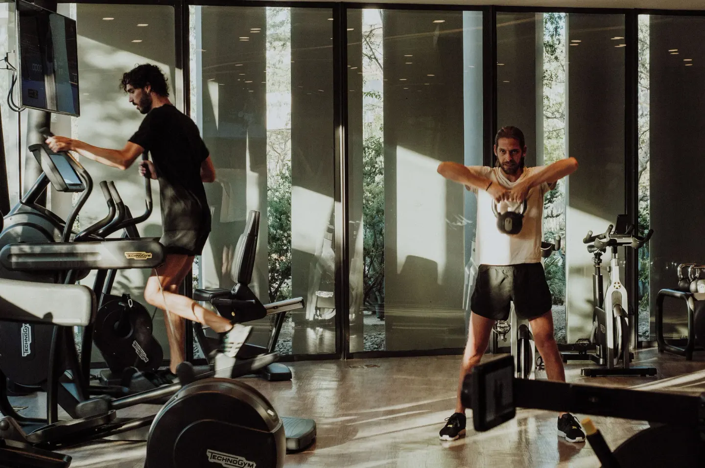 Two guests exercising with cardio and weight equipment at The Club at Solaz.