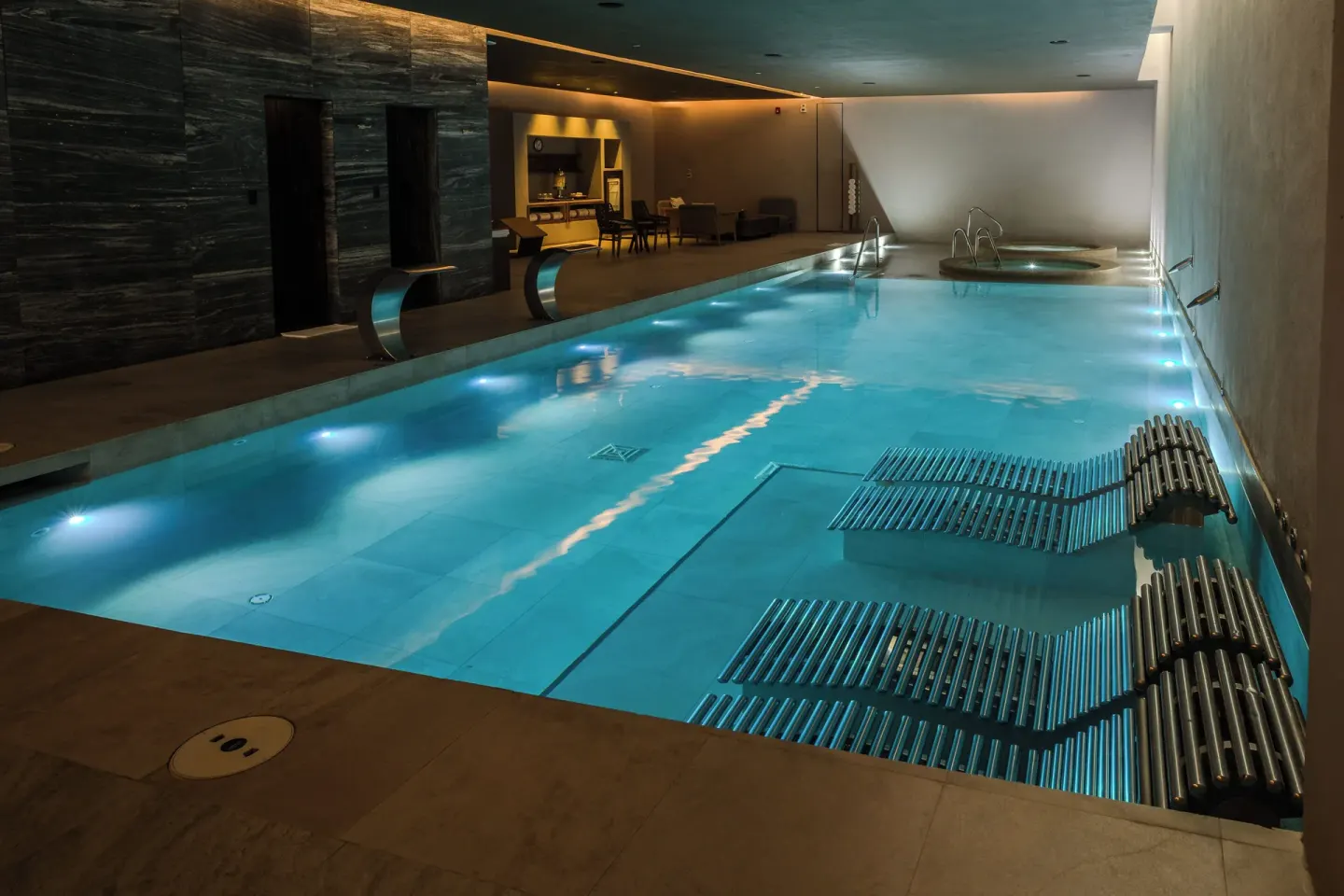 An indoor spa pool with submerged loungers at The Club at Solaz.