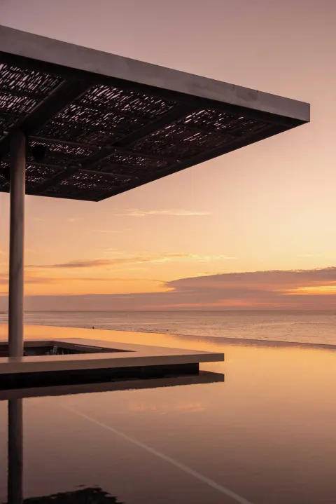 Pergola over an infinity pool facing the ocean at sunset at The Club at Solaz.