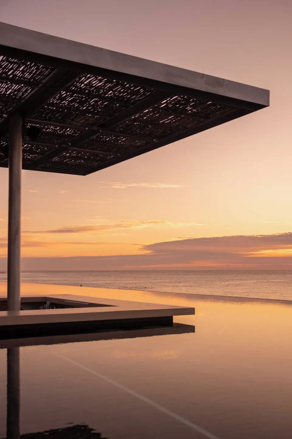 Pergola over an infinity pool facing the ocean at sunset at The Club at Solaz.