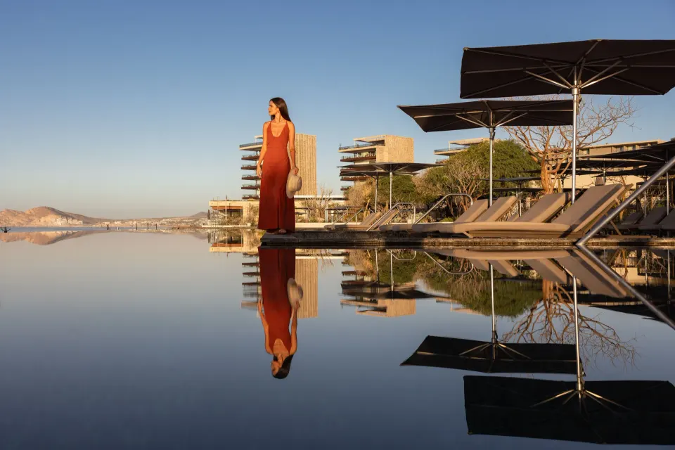Infinity pool with loungers, umbrellas, and resort buildings at The Club at Solaz.
