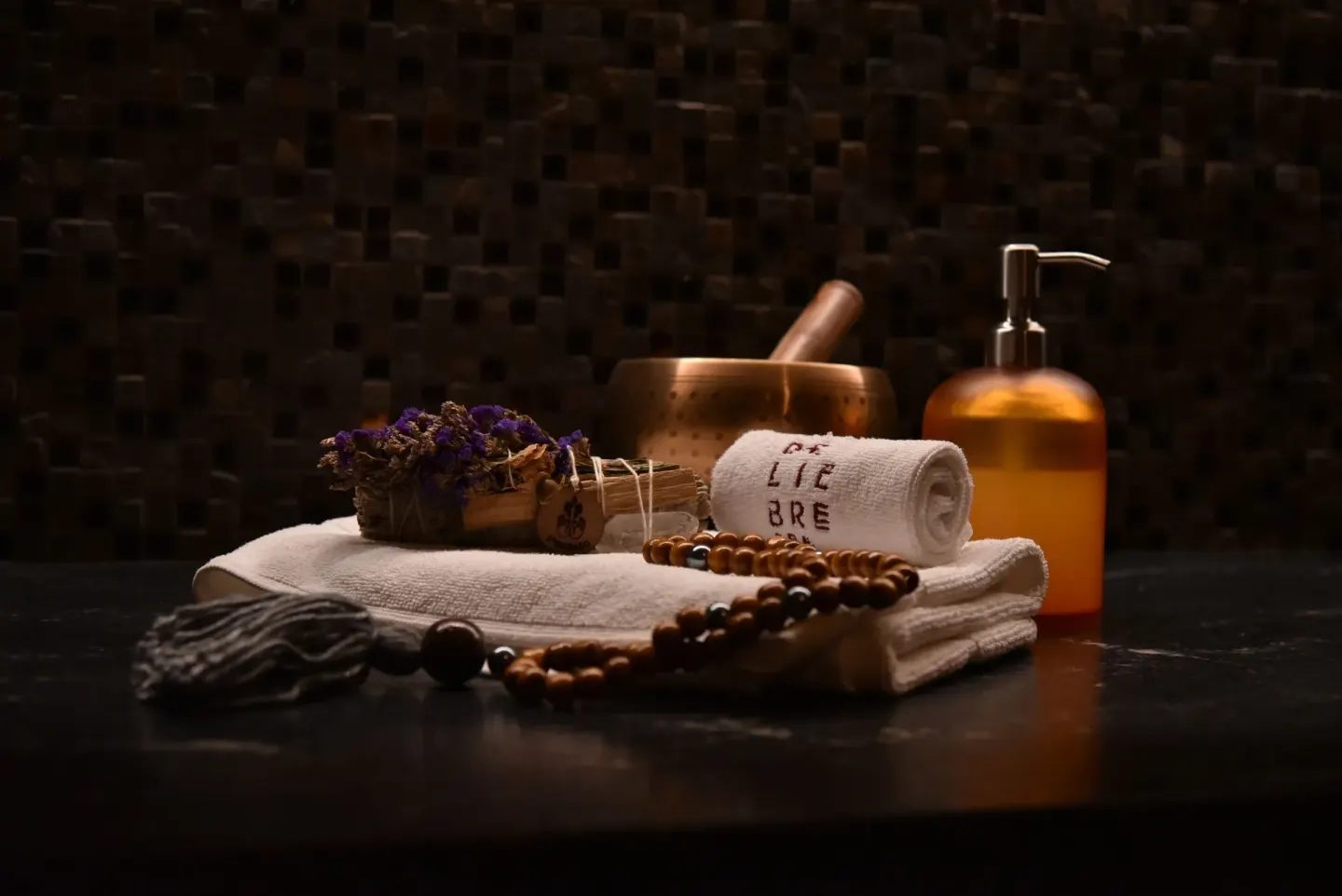 Spa towels, a bowl, beads, and a pump bottle at The Club at Solaz.