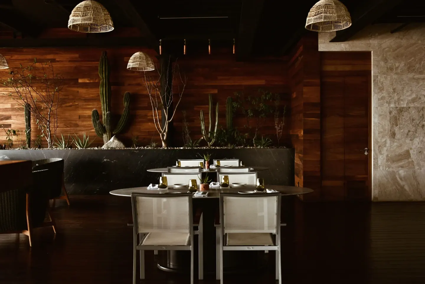 Set dining tables, cactus planters and woven pendant lights inside The Club at Solaz.