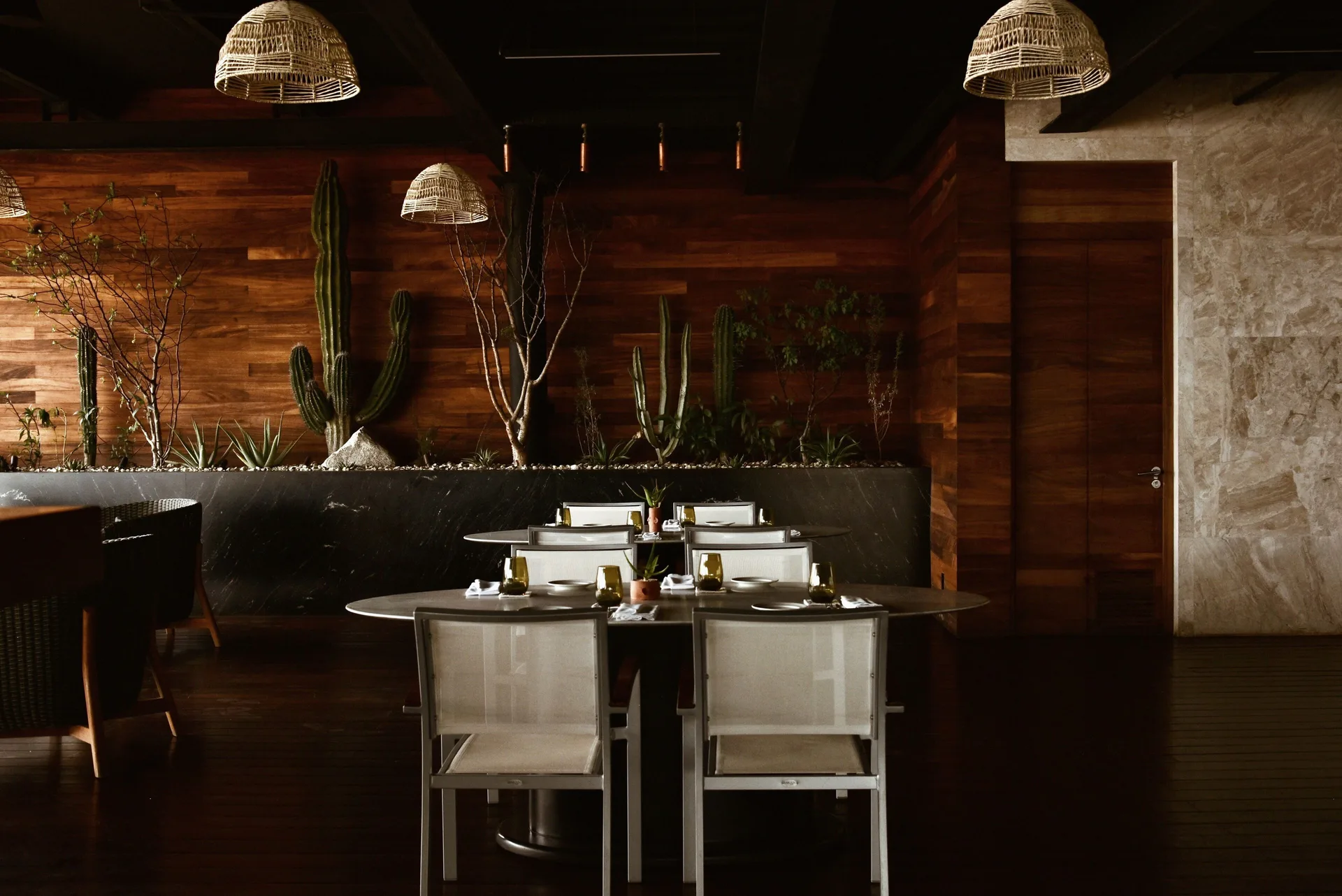 Set dining tables, cactus planters and woven pendant lights inside The Club at Solaz.