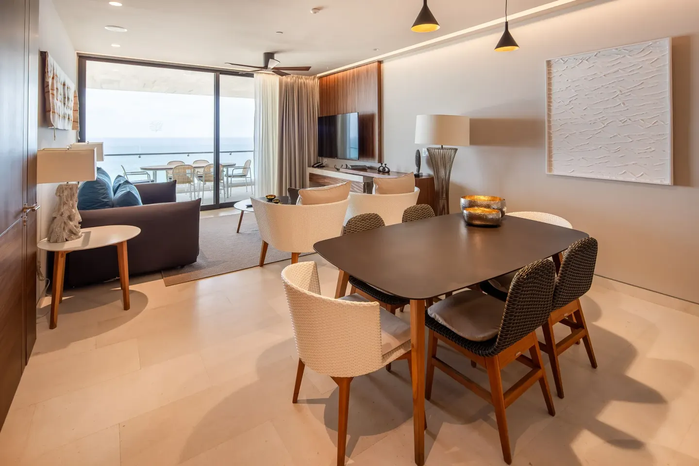 Dining and living area of a One Bedroom Villa Ocean View at The Club at Solaz opening to the balcony.