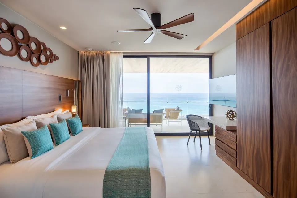 King bed in a One Bedroom Villa Ocean View at The Club at Solaz facing a balcony and ocean.