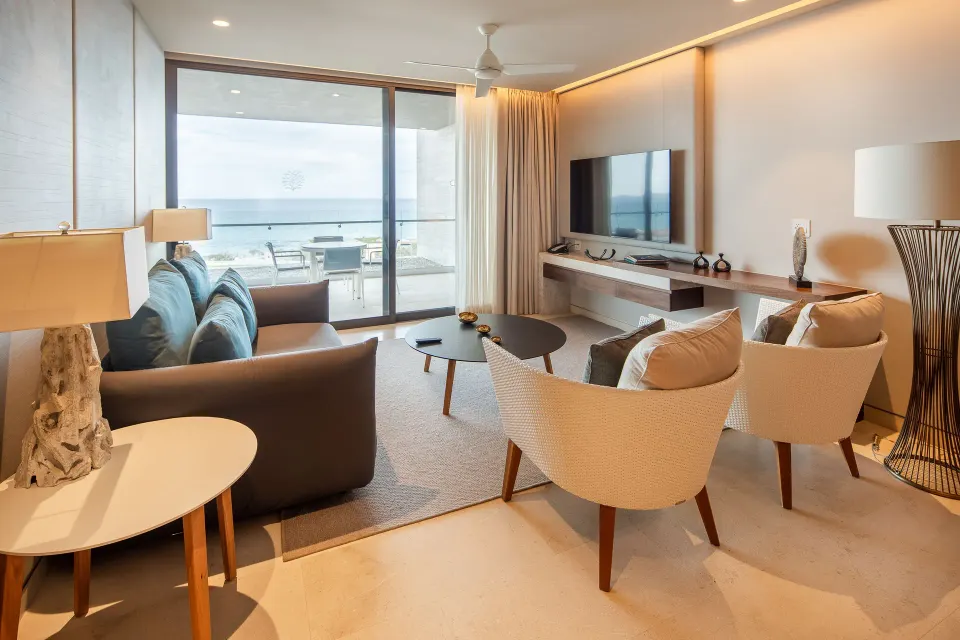 Ocean-view living room in a One Bedroom Villa at The Club at Solaz with balcony seating beyond.