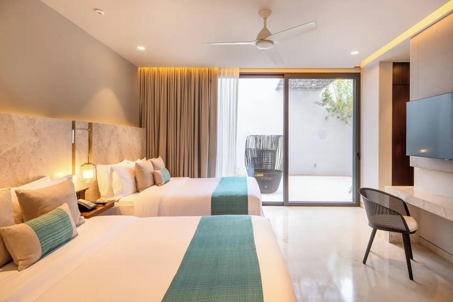 Two-bed villa bedroom with desk and private patio at The Club at Solaz.