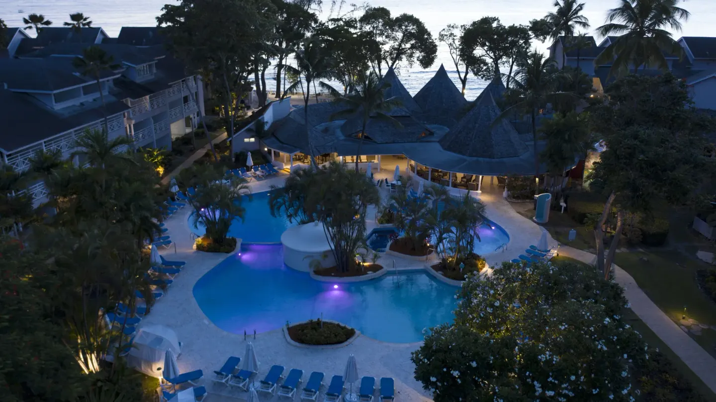 Elevated evening view of the resort pools and sea at The Club, Barbados Resort & Spa.