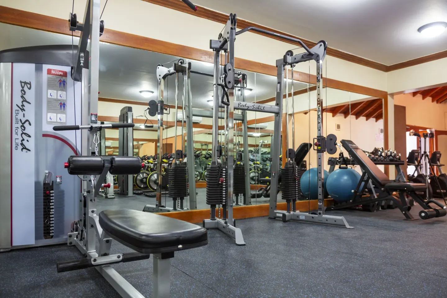 Fitness room with cable machines, benches and mirrors at The Club, Barbados Resort & Spa.