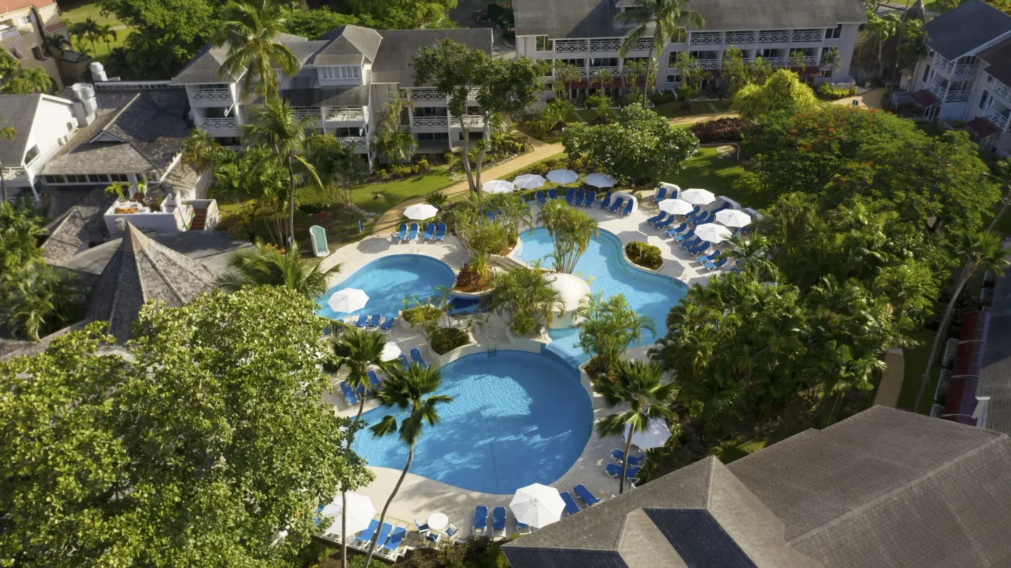 Aerial view of garden pools and loungers at The Club, Barbados Resort & Spa.