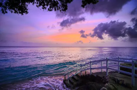 Purple sunset over the sea and stair railing at The Club, Barbados Resort & Spa.