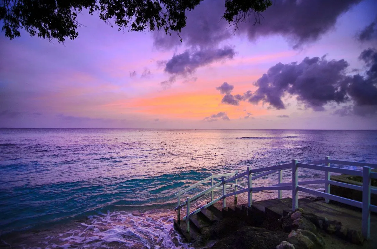 Purple sunset over the sea and stair railing at The Club, Barbados Resort & Spa.