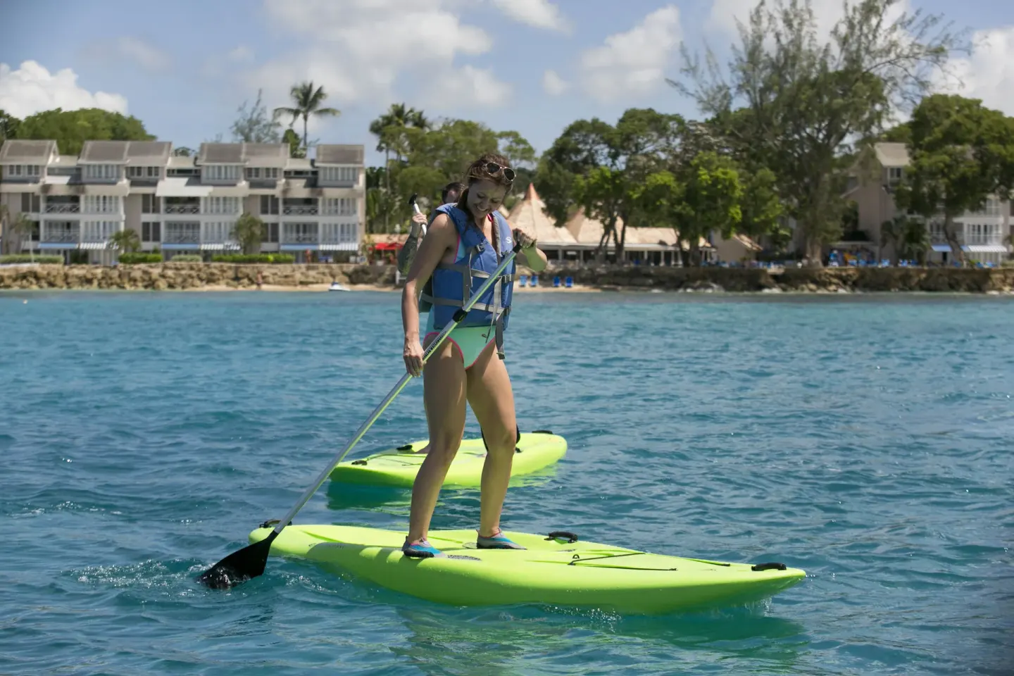 Guests paddleboarding on turquoise water at The Club, Barbados Resort & Spa.