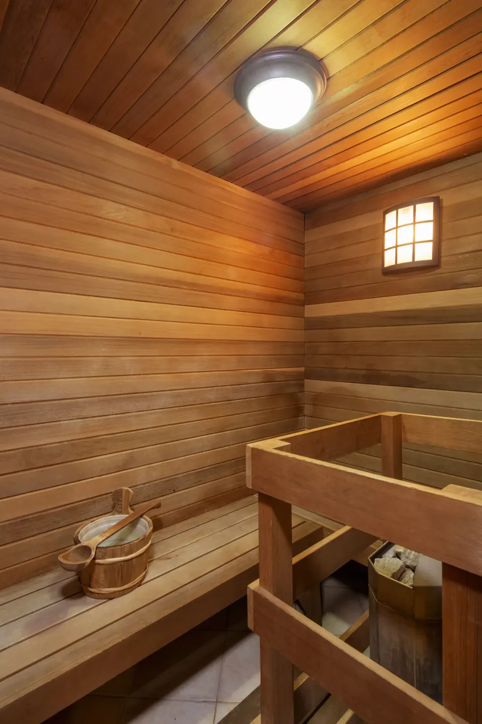 Wood-lined sauna with bench and bucket at The Club, Barbados Resort & Spa.