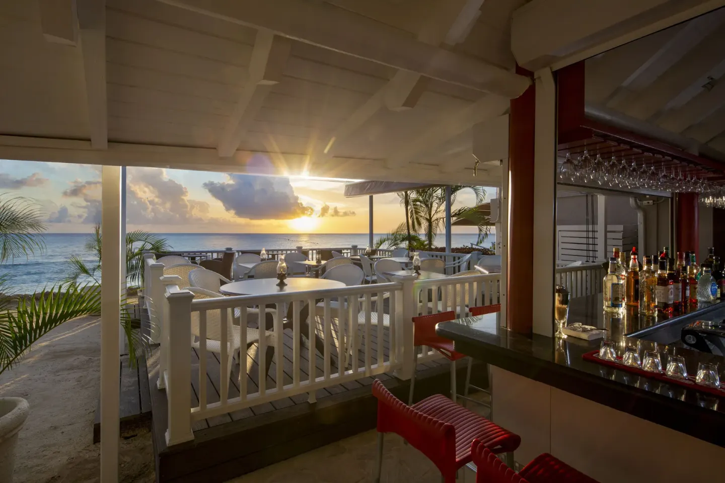 Seaside bar terrace at sunset at The Club, Barbados Resort & Spa.