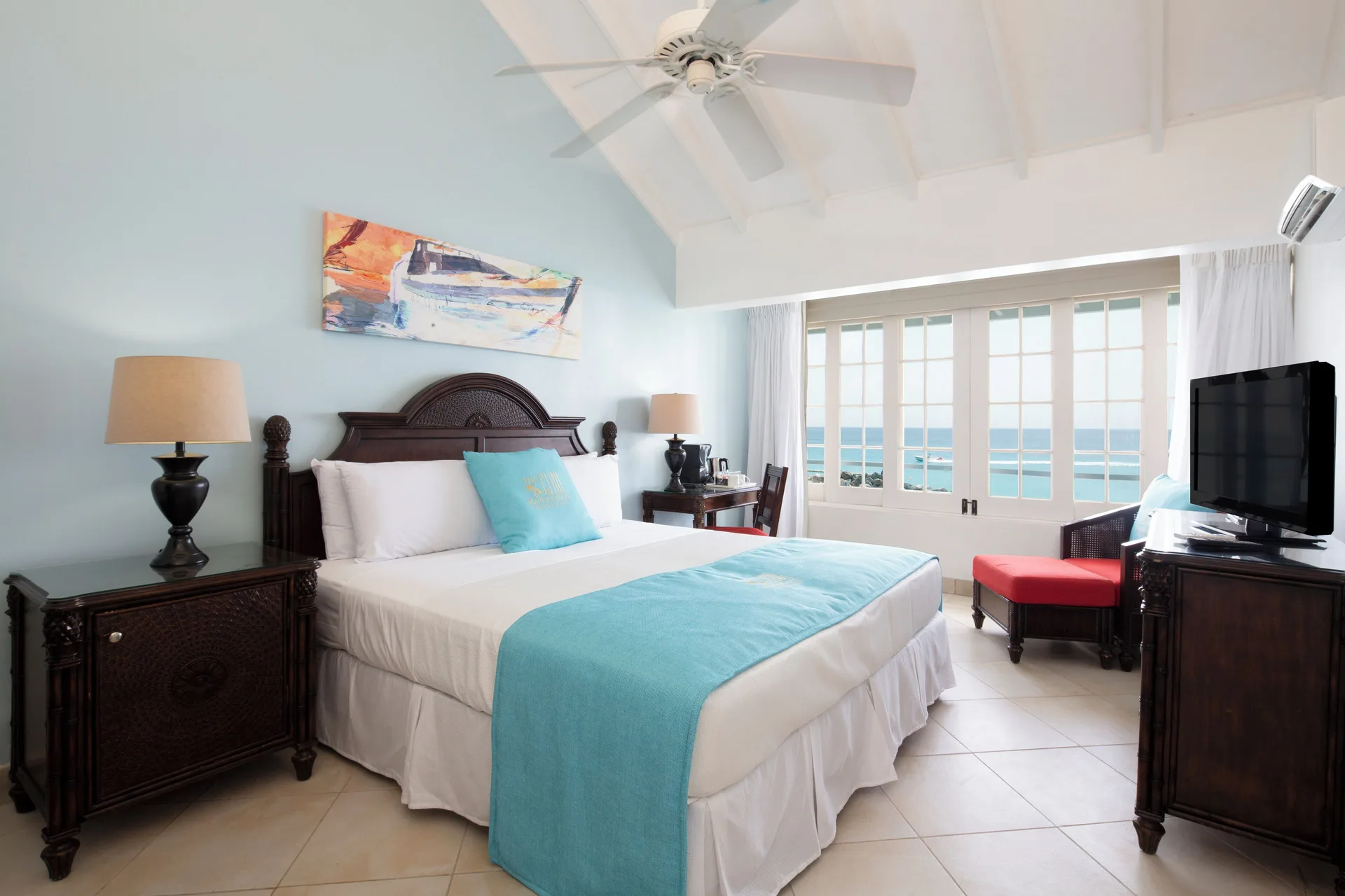 Ocean Loft king bed with sea-facing doors at The Club, Barbados Resort & Spa.