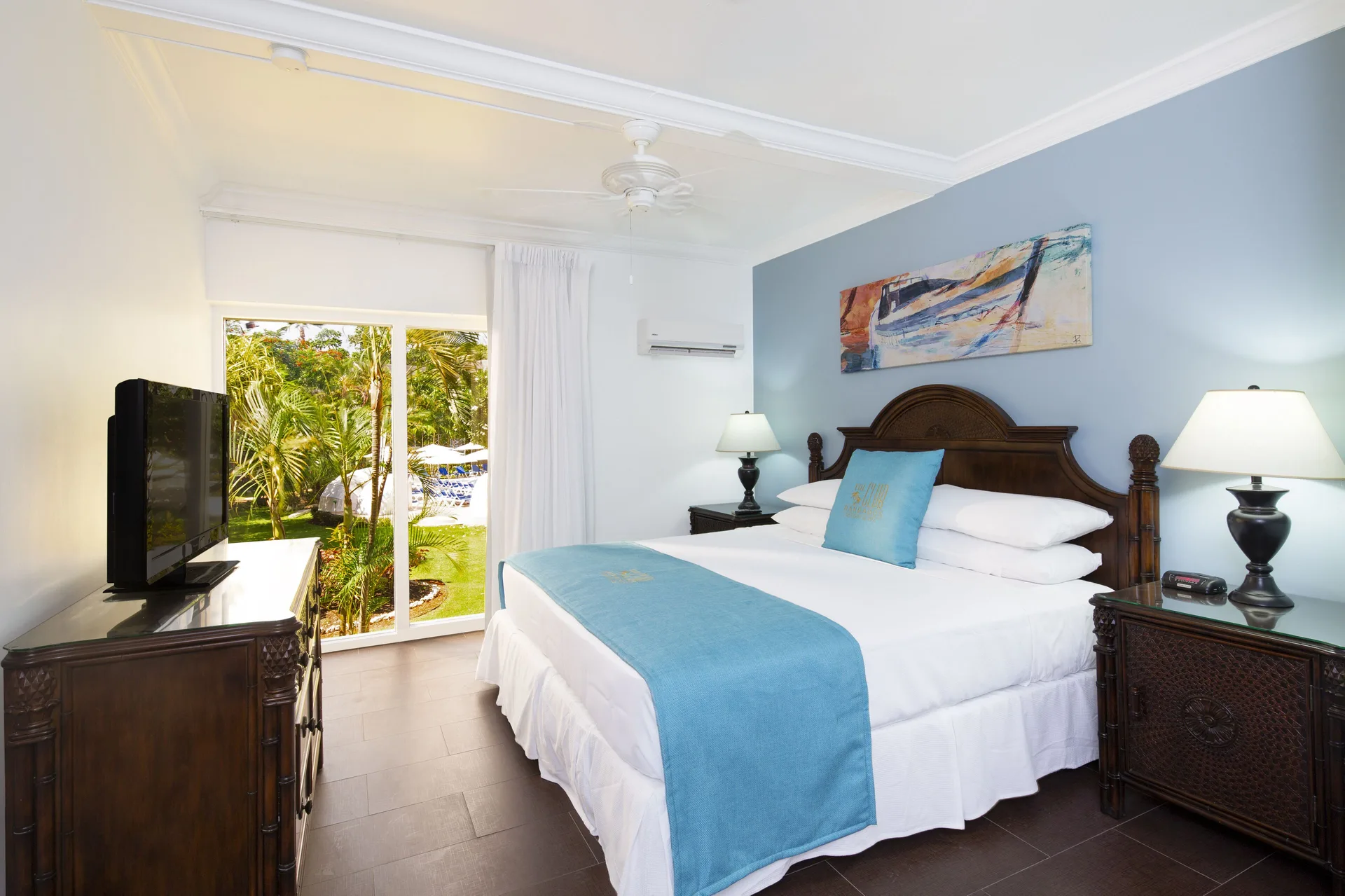 One Bedroom Garden View Suite bedroom with king bed and garden-facing doors at The Club, Barbados Resort & Spa.