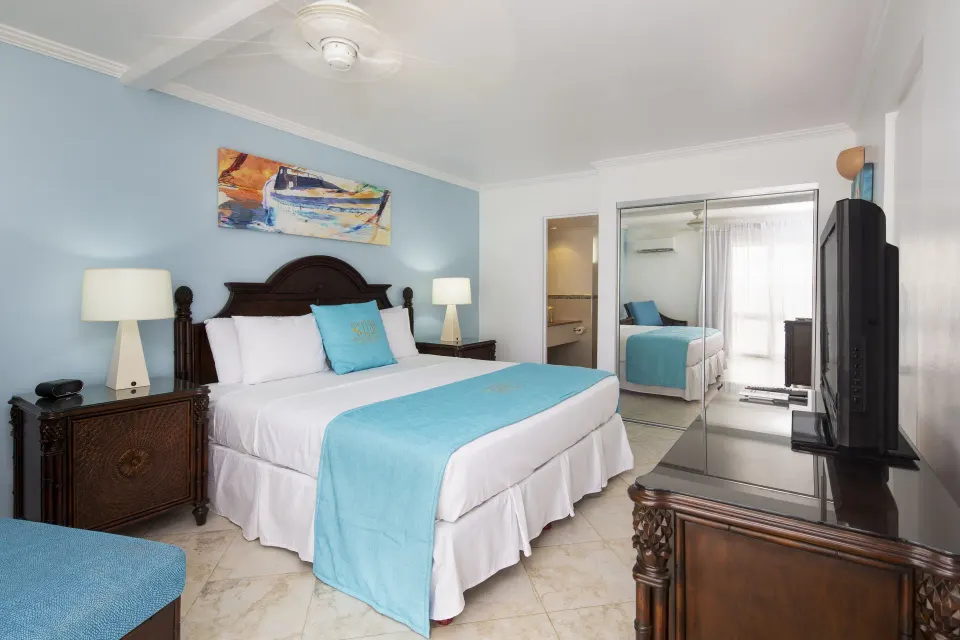 One Bedroom Oceanfront Suite king bedroom with mirrored closet at The Club, Barbados Resort & Spa.