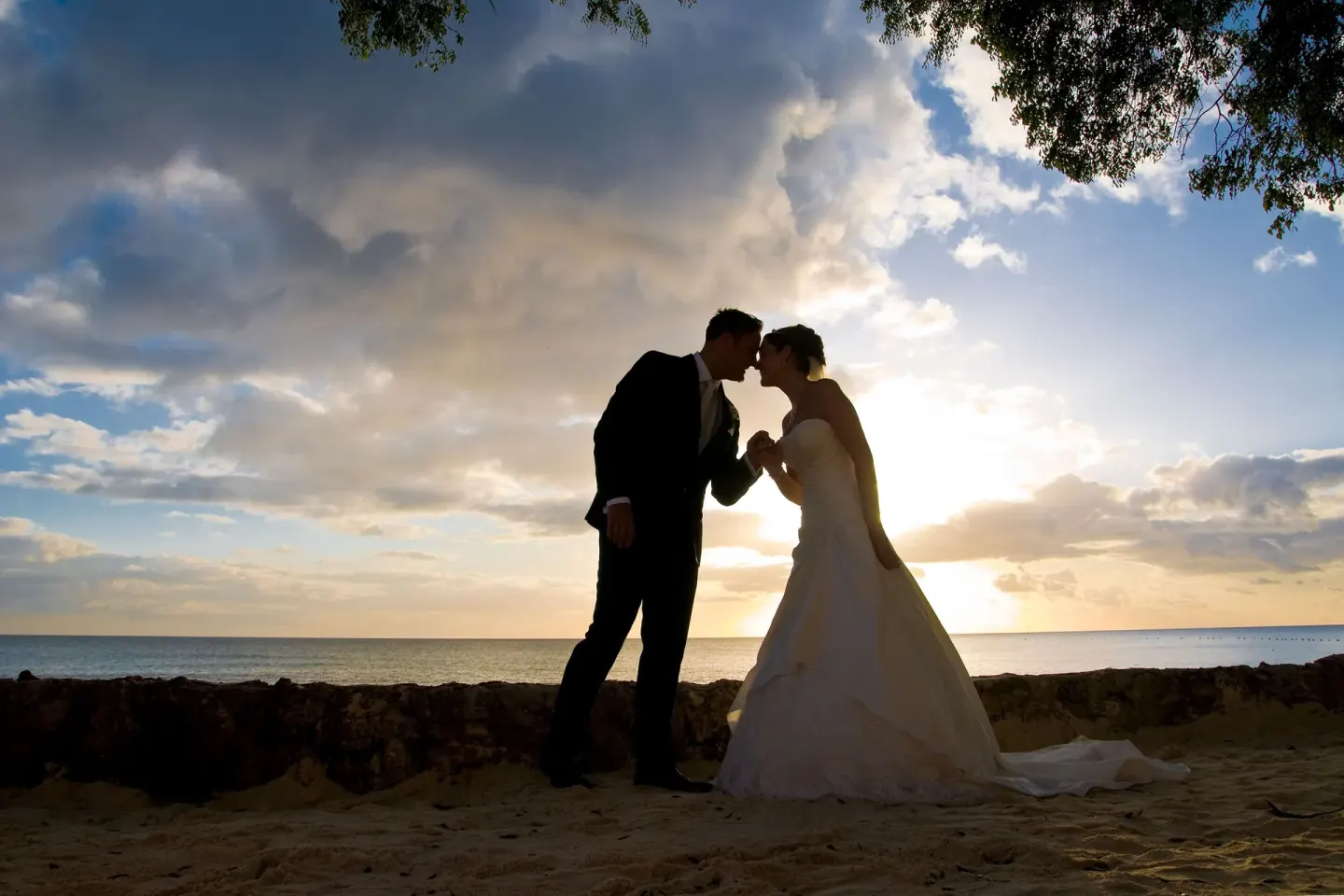 Bride and groom silhouetted on the beach at The Club, Barbados Resort & Spa.