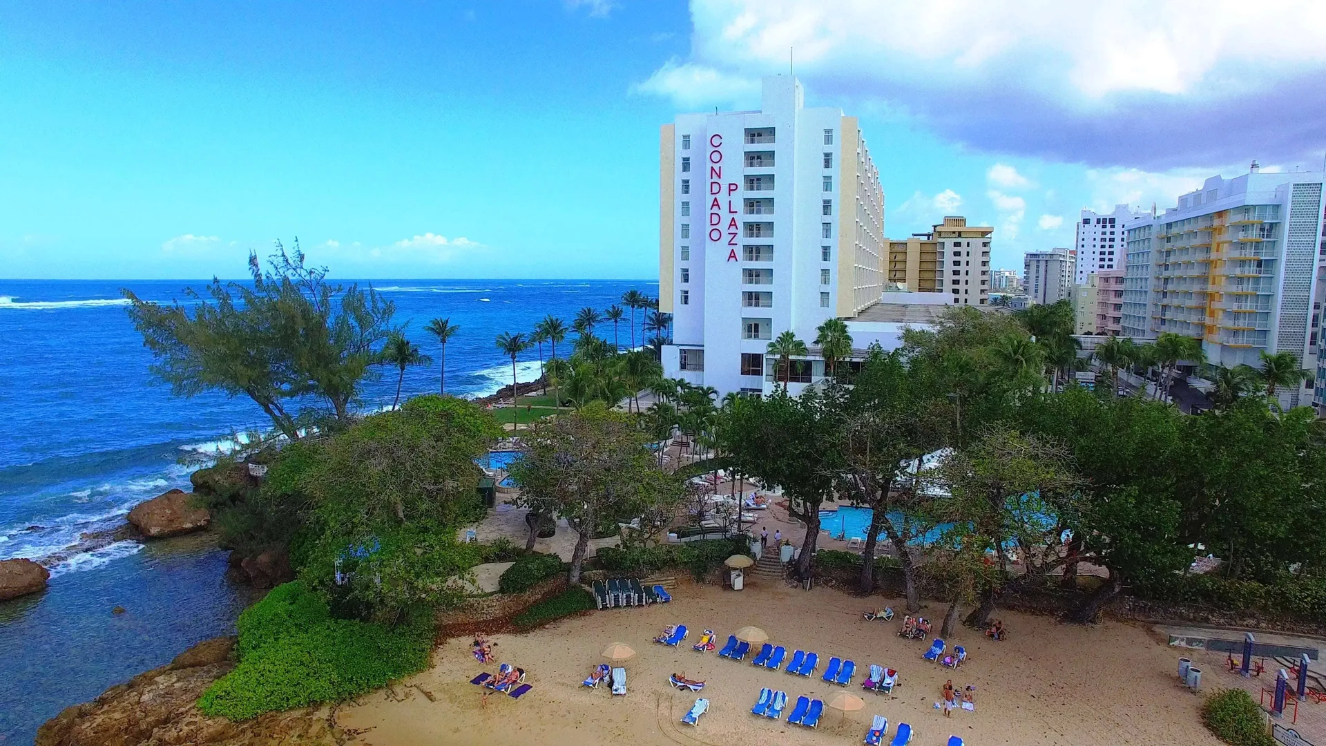 Beach, pools, and oceanfront tower at The Condado Plaza Hotel.
