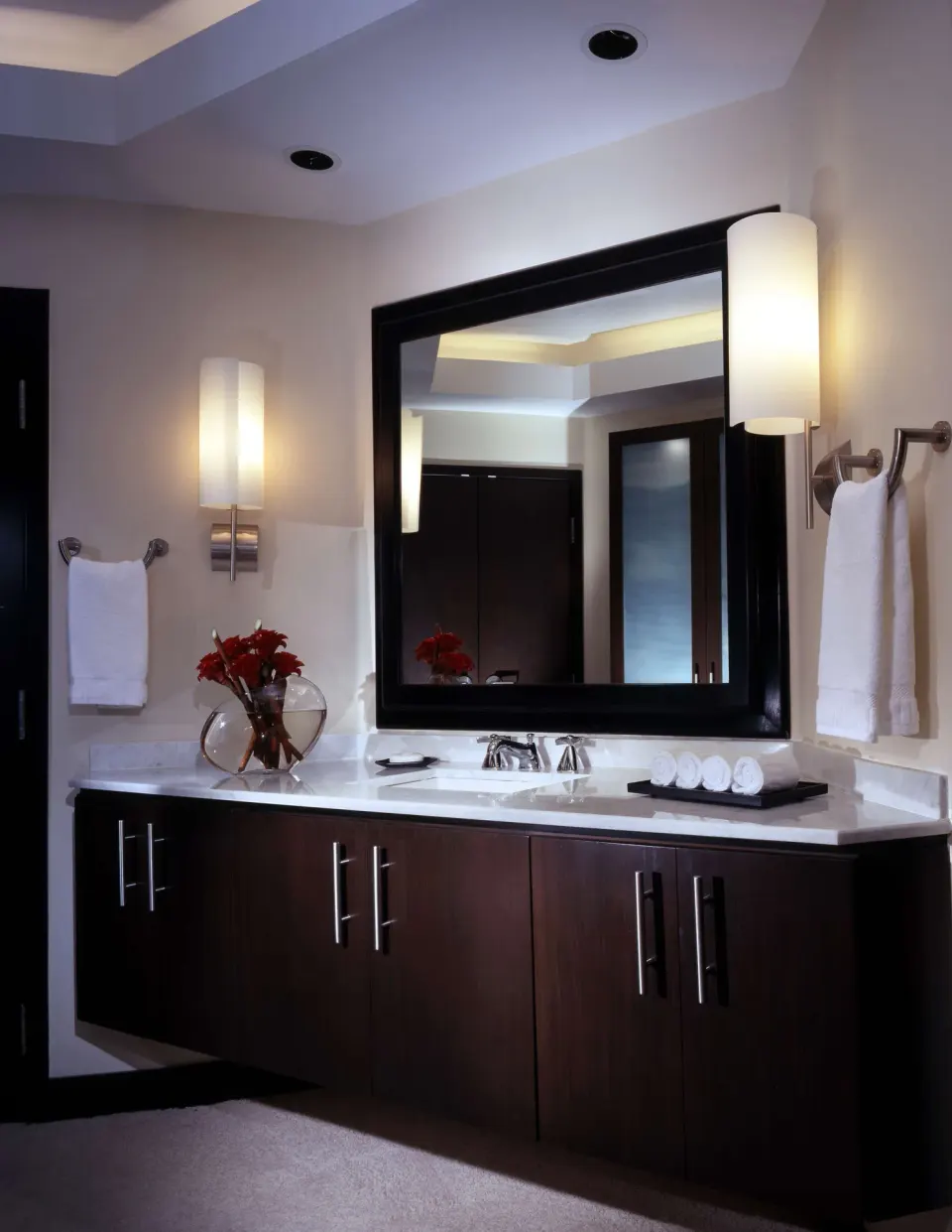 Wide bathroom vanity with illuminated sconces at The Condado Plaza Hotel.