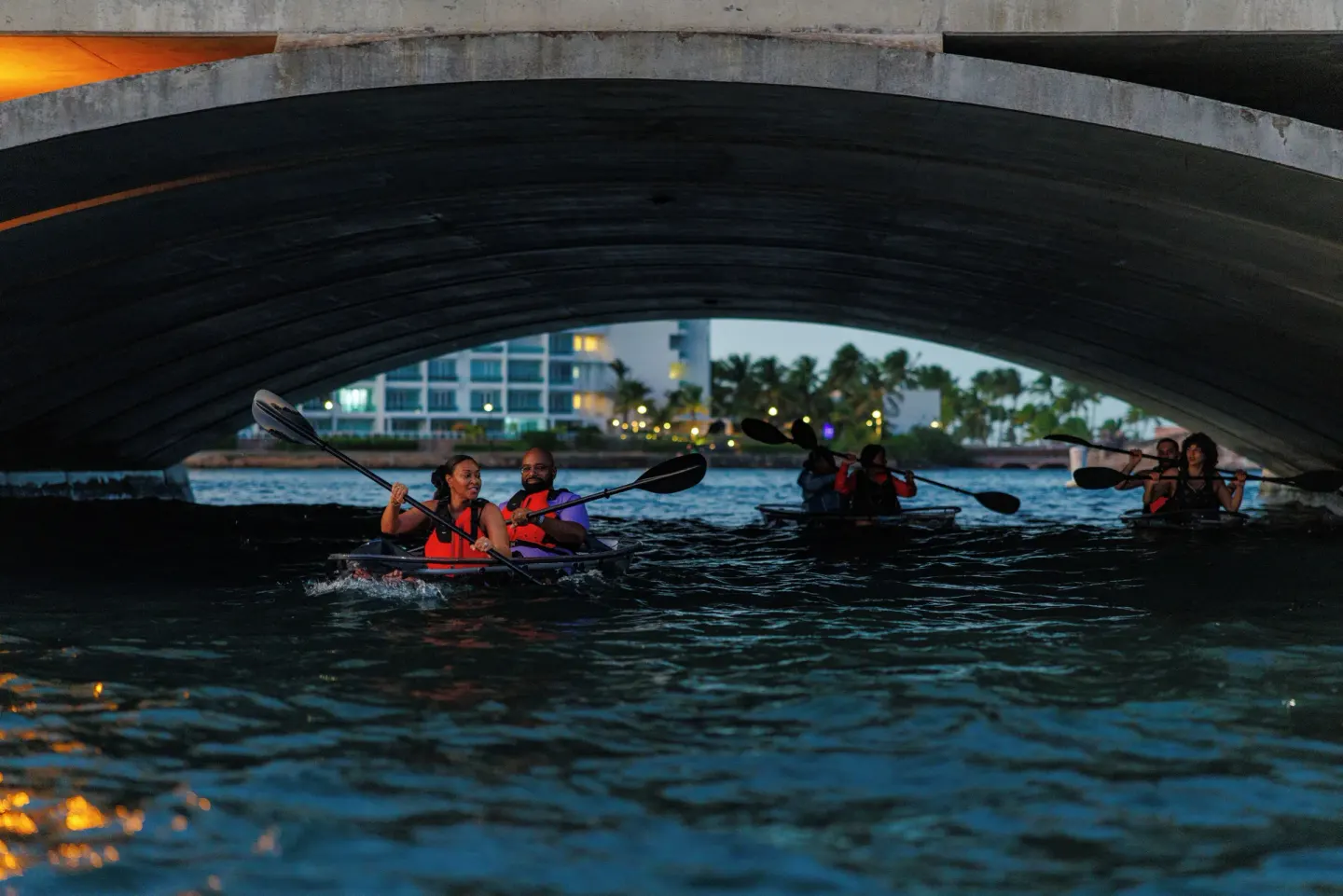 Kayakers paddle beneath a bridge on the lagoon near The Condado Plaza Hotel.
