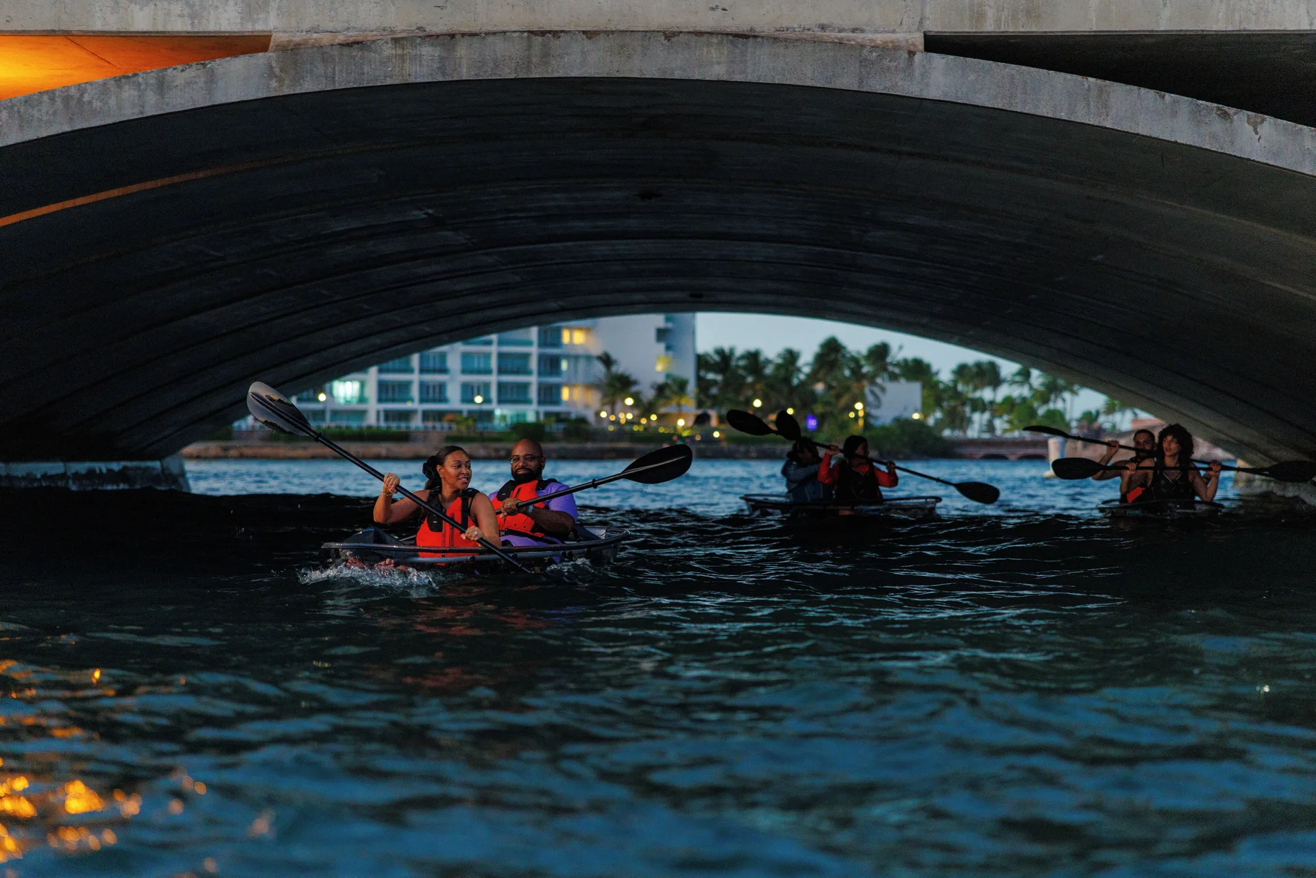 Kayakers paddle beneath a bridge on the lagoon near The Condado Plaza Hotel.