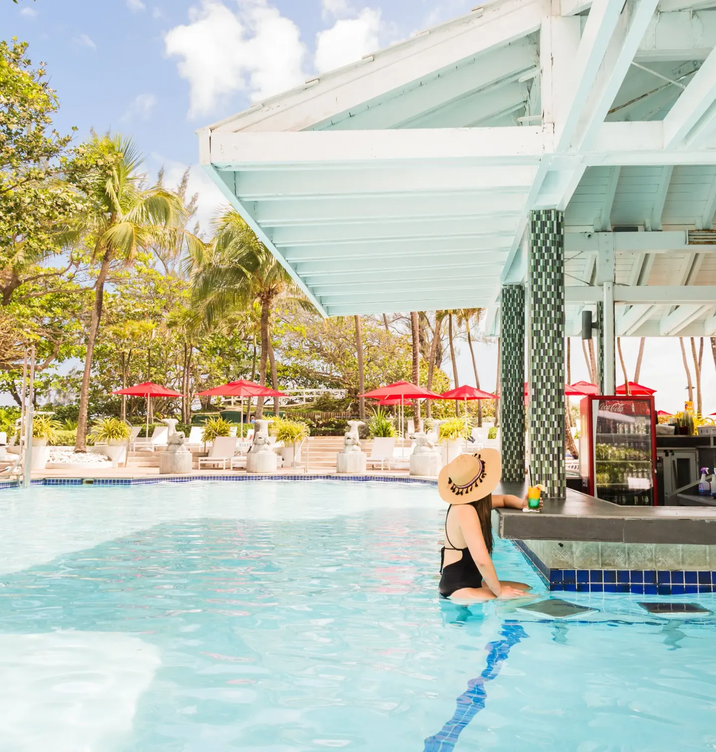 Swim-up pool bar with red umbrellas at The Condado Plaza Hotel.