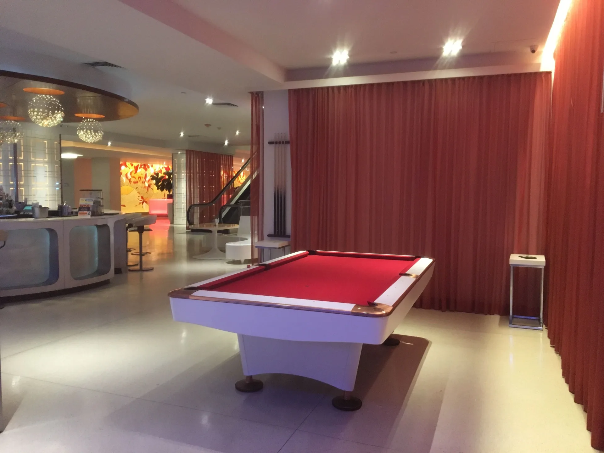 Red-felt pool table and bar area inside The Condado Plaza Hotel lounge space.