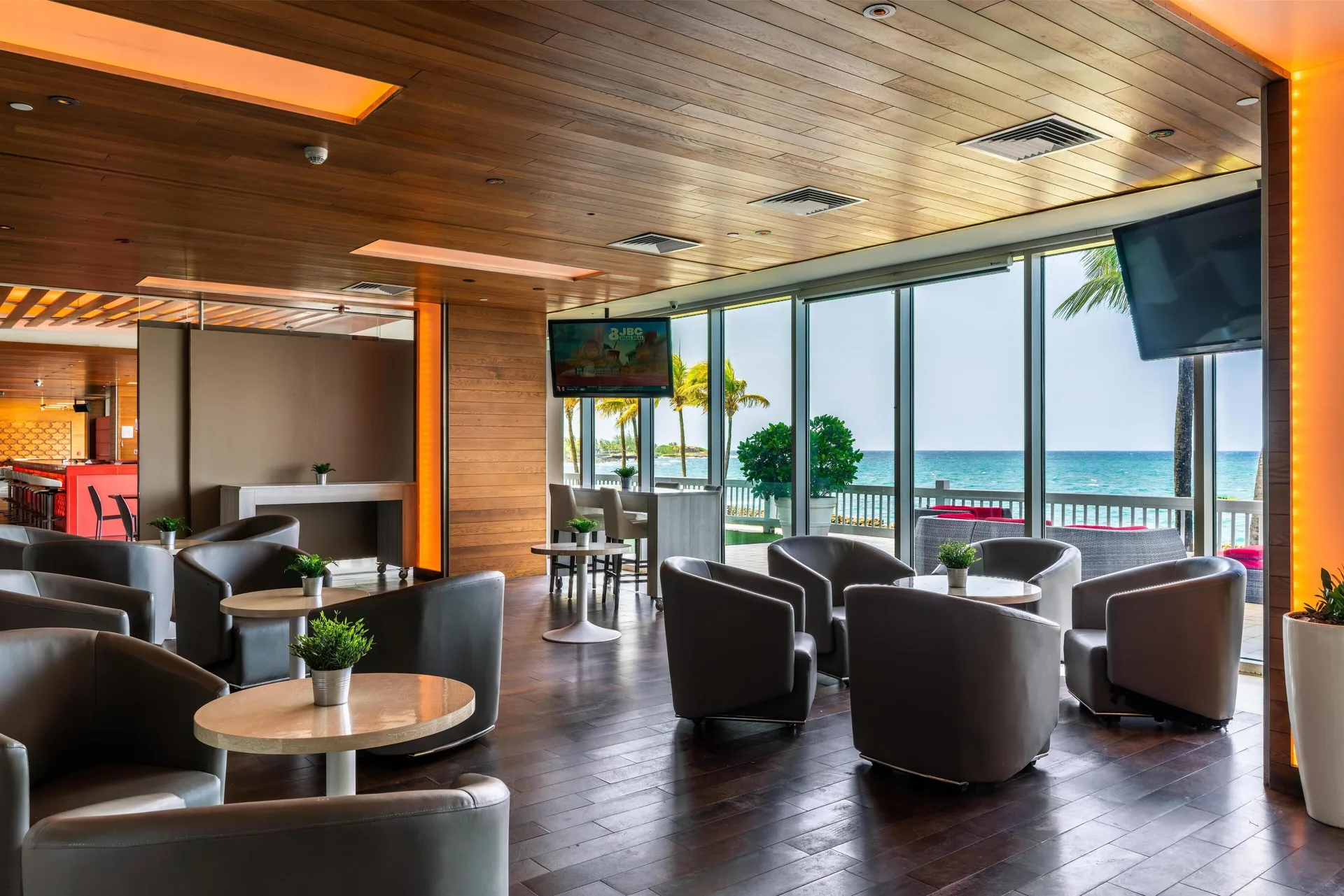 Oceanfront lounge seating with round tables at The Condado Plaza Hotel.