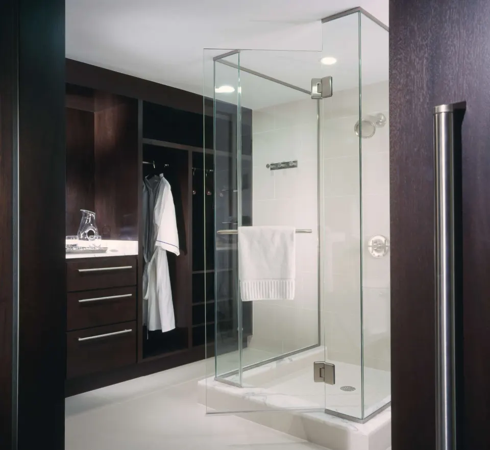 Deluxe Room bathroom with glass shower and open wardrobe at The Condado Plaza Hotel.