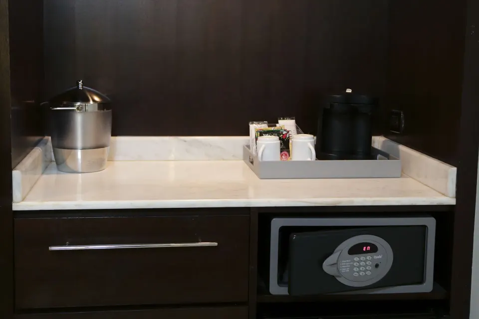 In-room refreshment counter with ice bucket, coffee setup, and safe at The Condado Plaza Hotel.