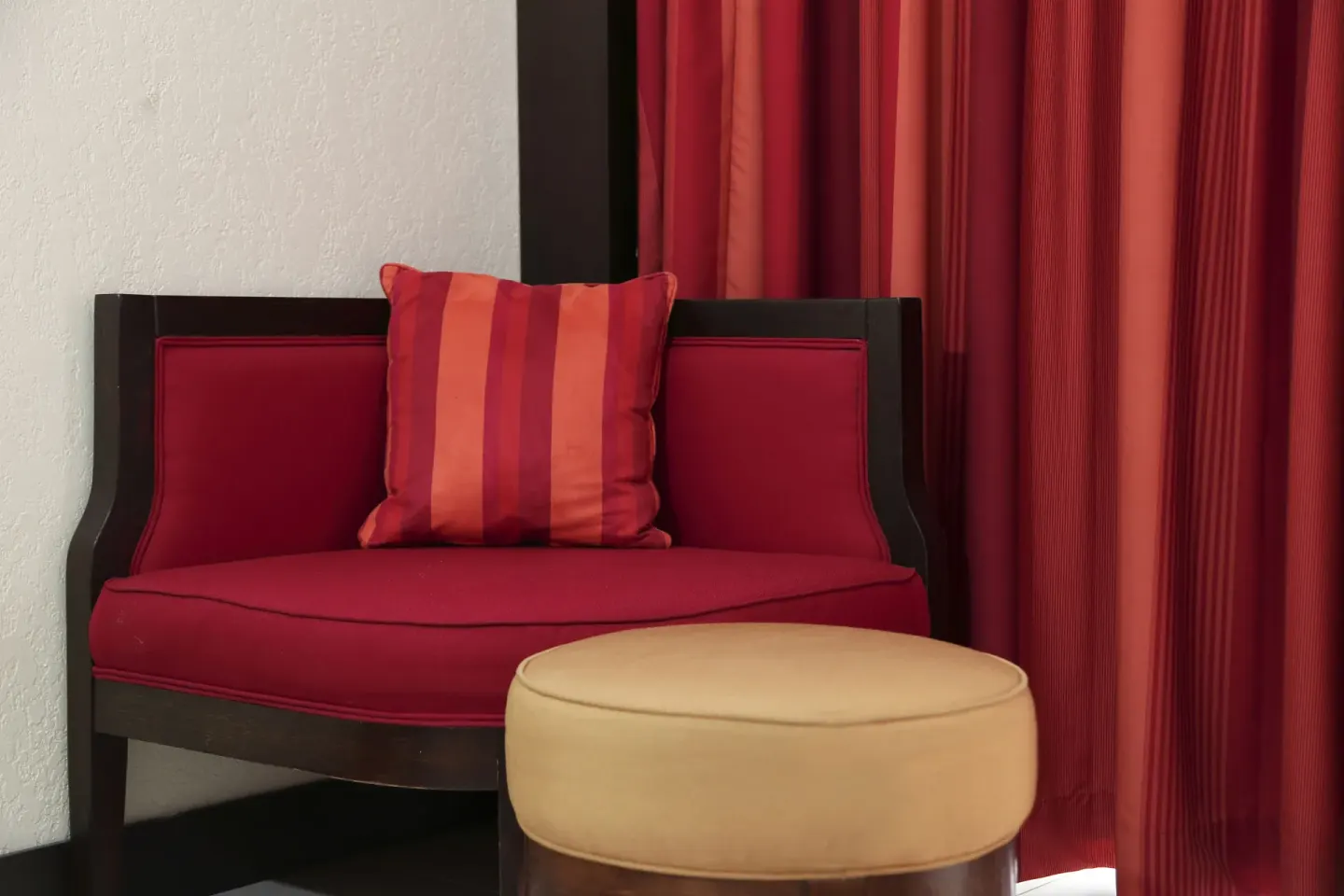 Red lounge chair and ottoman in a Deluxe Room at The Condado Plaza Hotel.