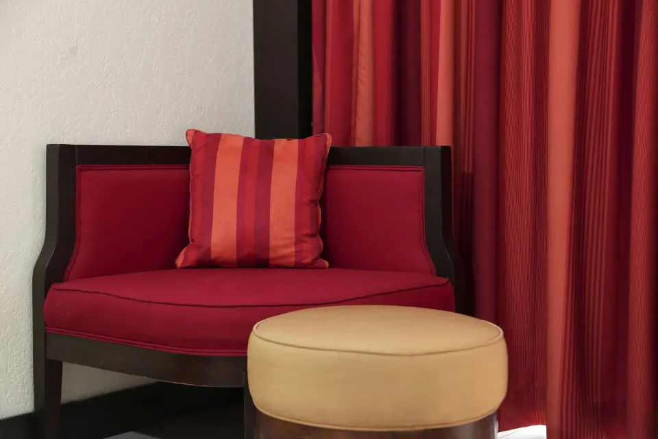 Red lounge chair and ottoman in a Deluxe Room at The Condado Plaza Hotel.