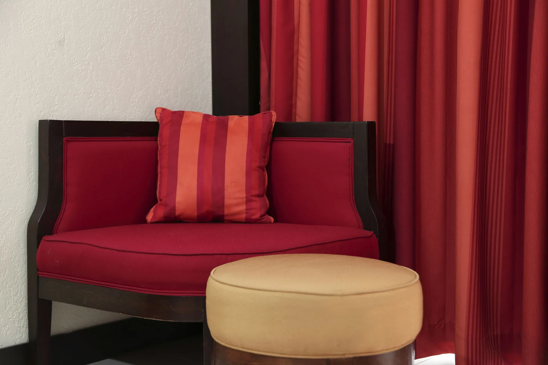 Red lounge chair and ottoman in a Deluxe Room at The Condado Plaza Hotel.
