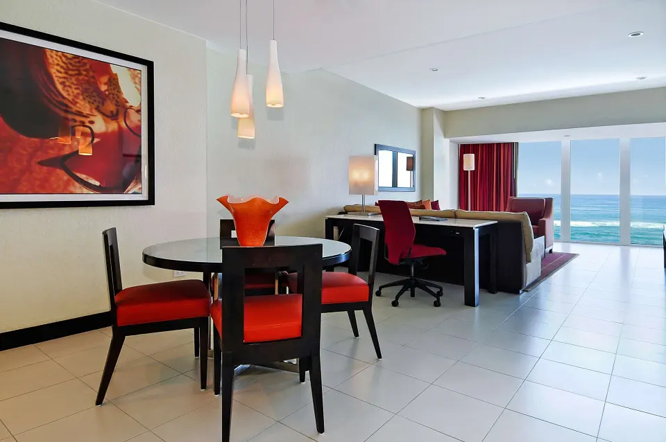 Oceanfront deluxe suite dining table and work area by ocean windows at The Condado Plaza Hotel.