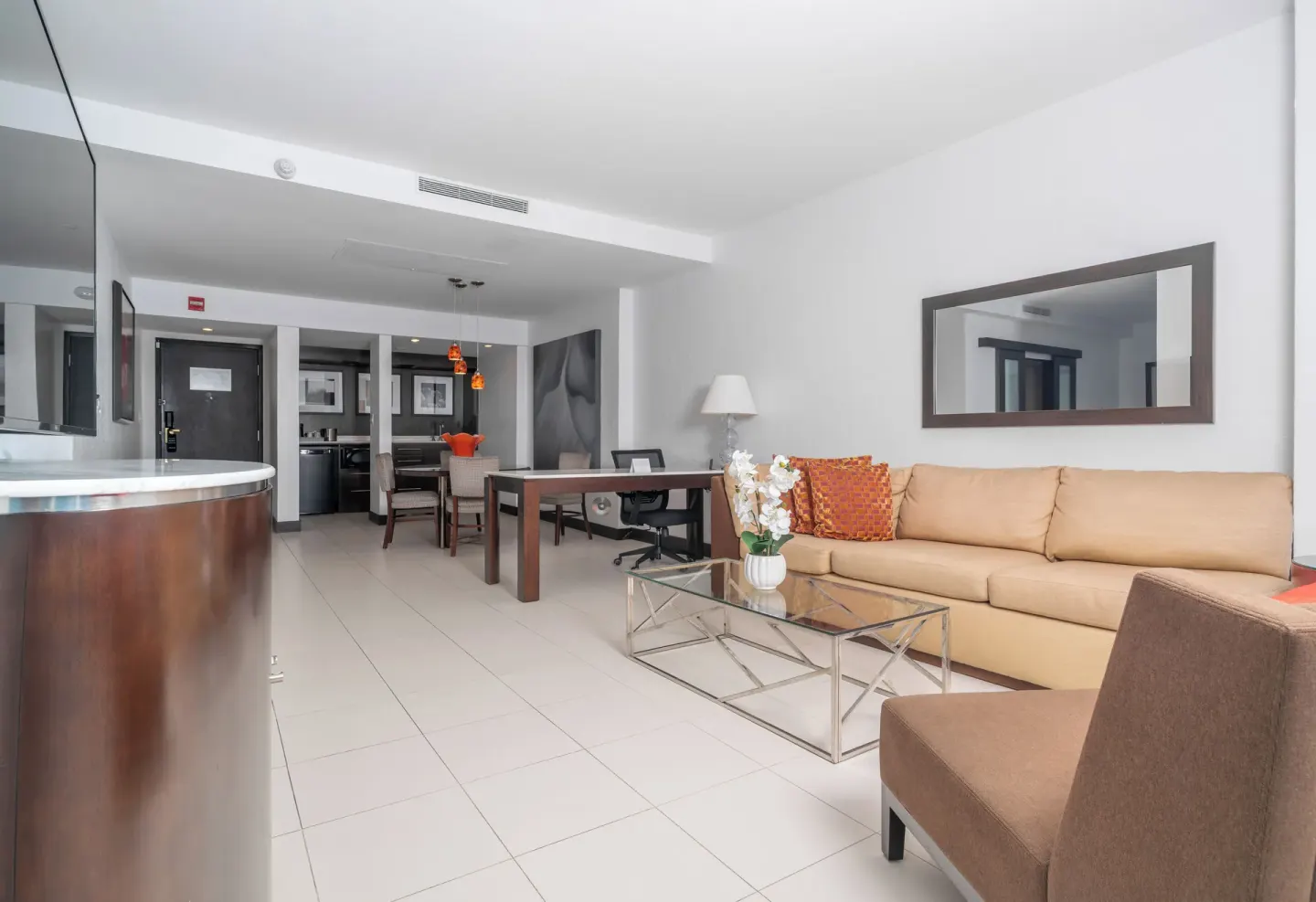 Oceanfront deluxe suite living room with sofa, desk, and bar counter at The Condado Plaza Hotel.