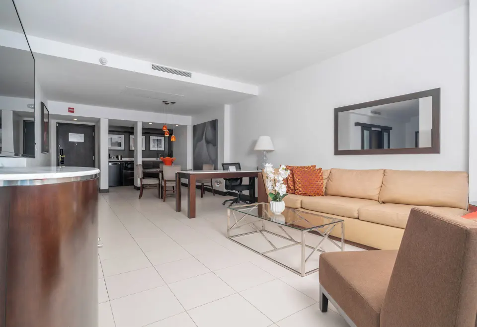 Oceanfront Deluxe Suite lounge with sofa and desk at The Condado Plaza Hotel.
