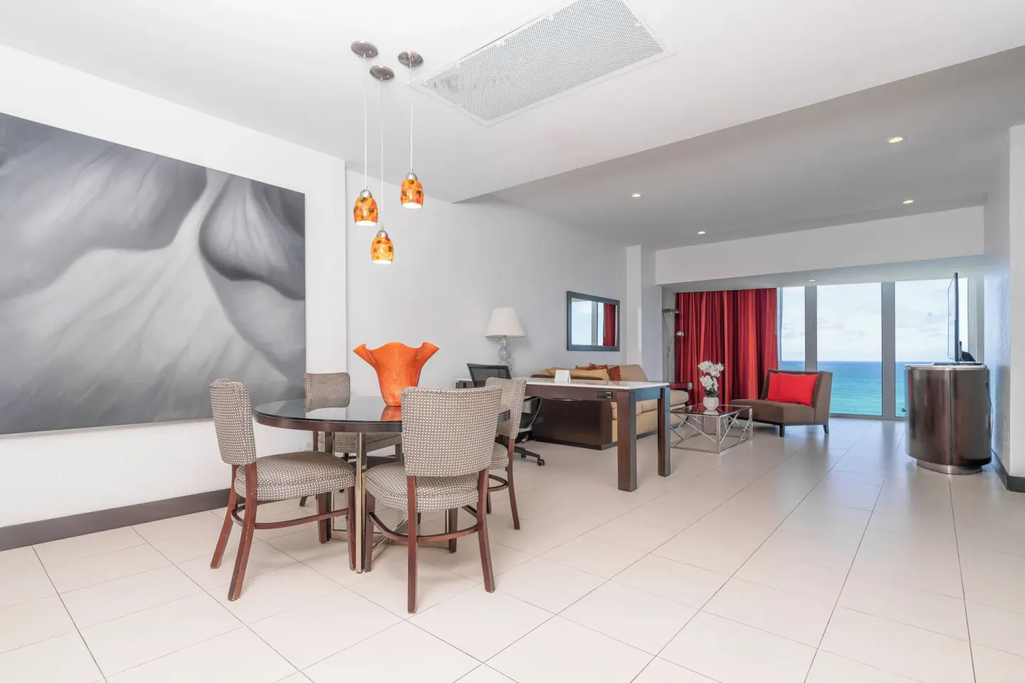 Oceanfront Deluxe Suite open living area with dining table at The Condado Plaza Hotel.