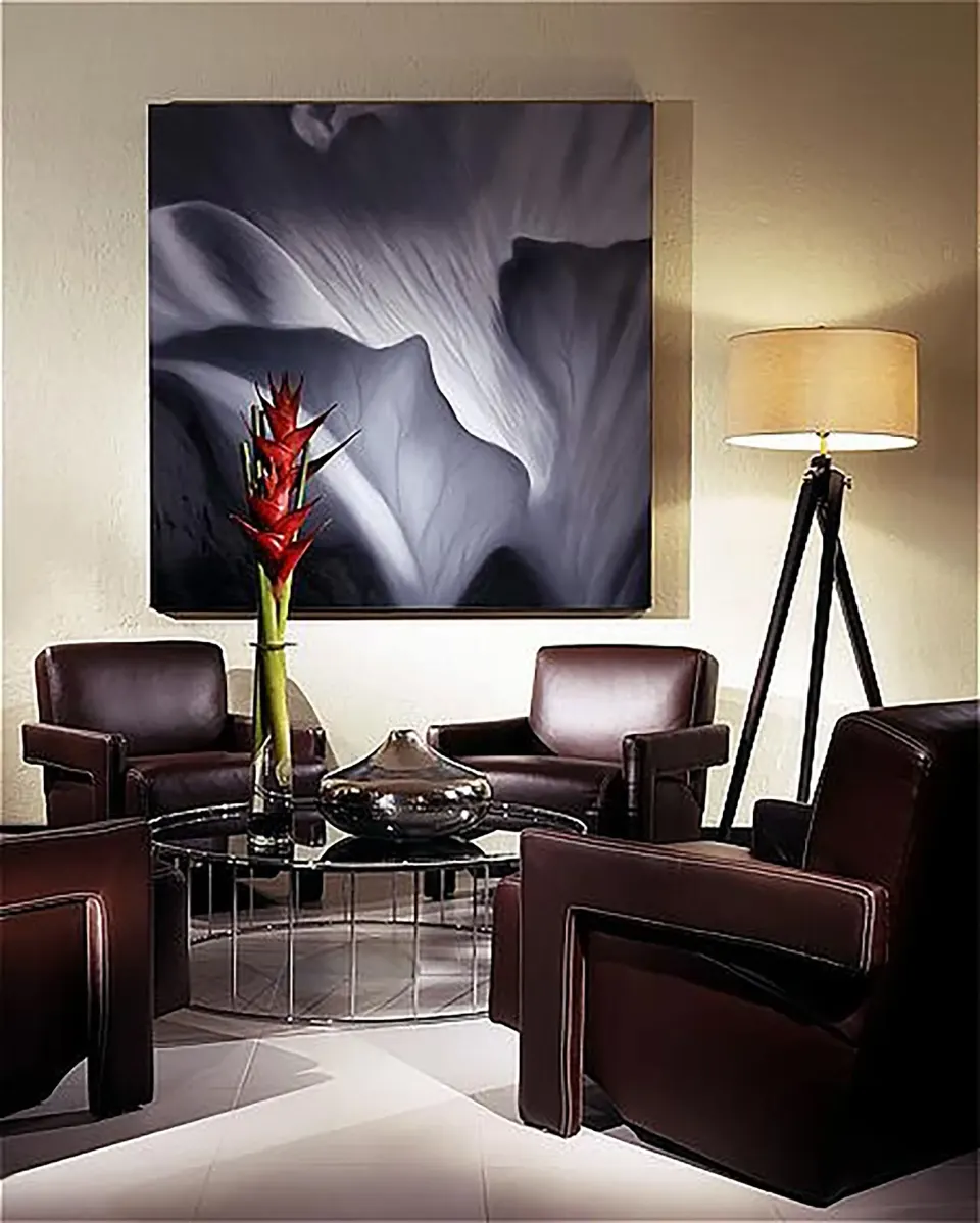 Seating area with leather chairs, flower art, and floor lamp in an oceanfront penthouse suite at The Condado Plaza Hotel.