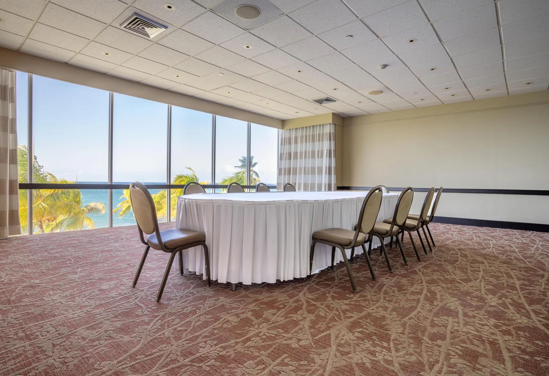 Conference room with U-shaped tables and ocean-facing windows at The Condado Plaza Hotel.