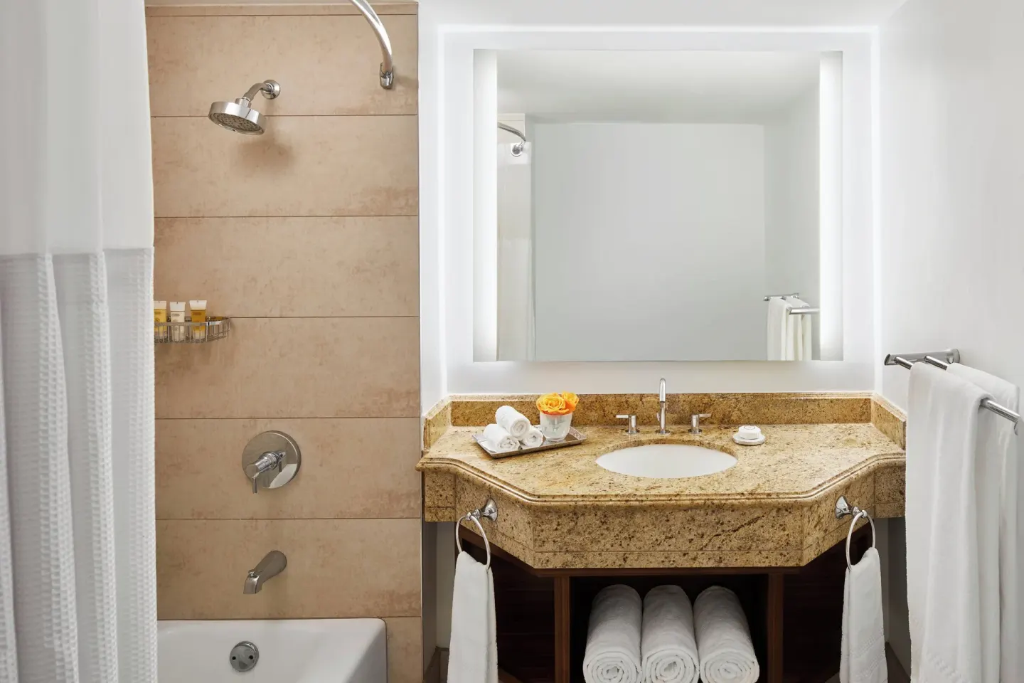 Guest bathroom with illuminated mirror and tub-shower at The Coral at Atlantis.