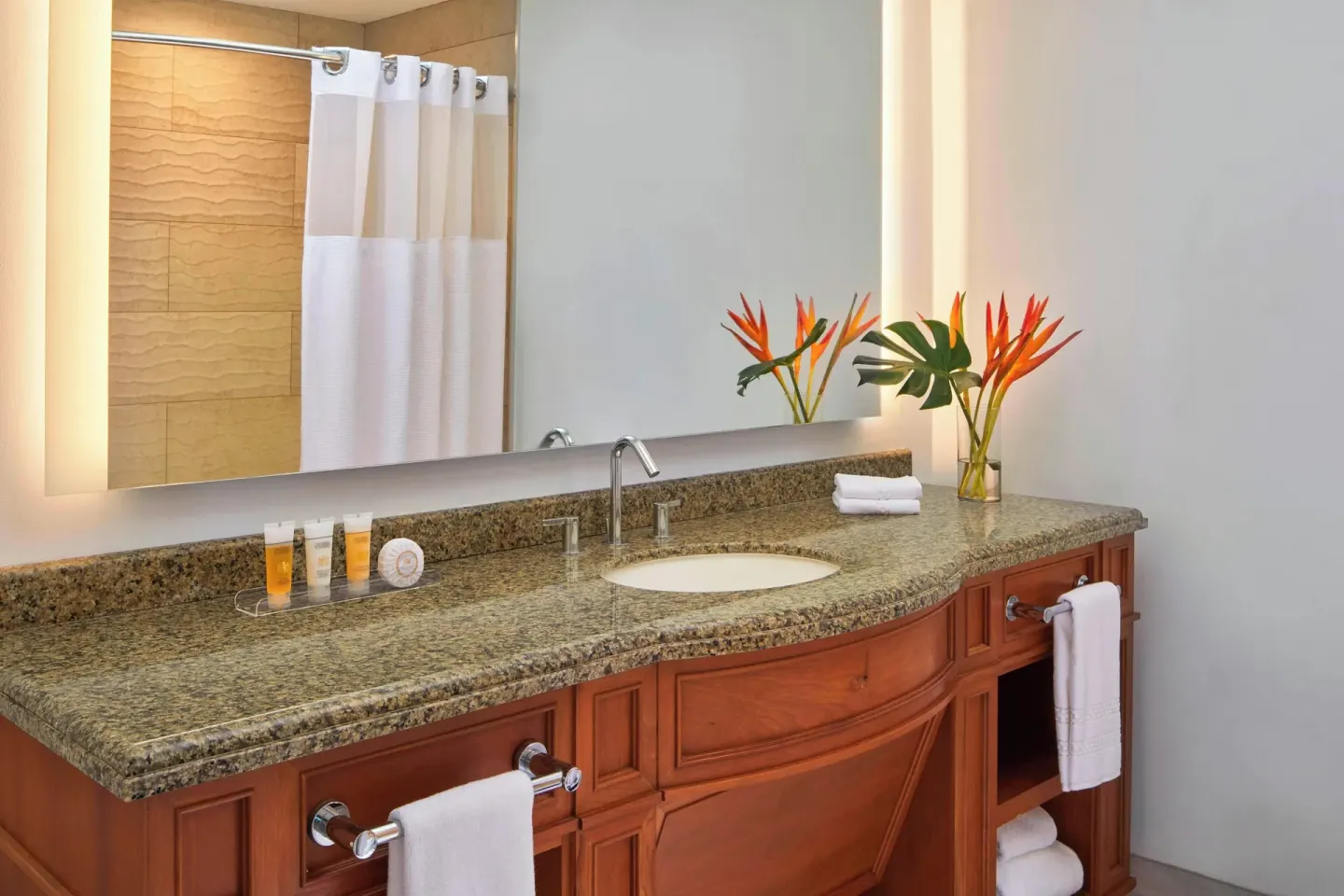 Guest bathroom vanity with flowers and bath amenities at The Coral at Atlantis.