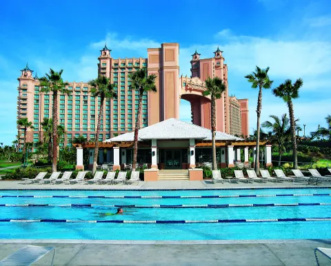 A lap pool with lane markers sits before the resort towers at The Coral at Atlantis.