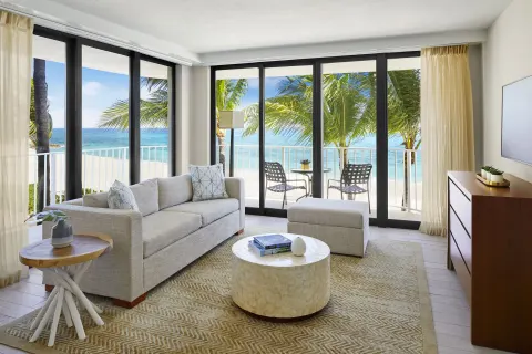 Living room in a 1 Bedroom Regal Suite at The Coral at Atlantis with balcony and ocean view.