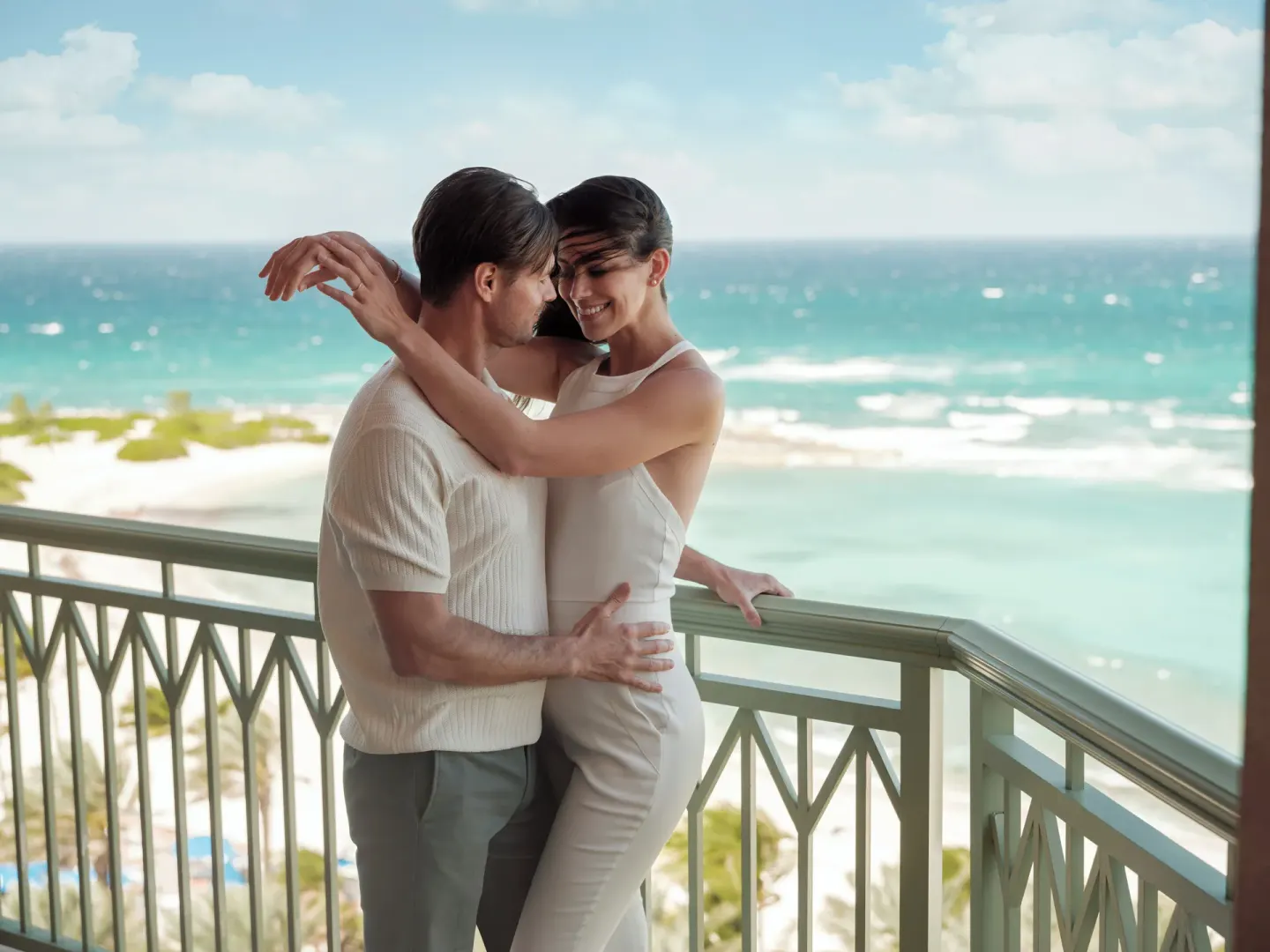 Couple on the balcony of a 1 Bedroom Sapphire Suite at The Cove at Atlantis overlooking the ocean.
