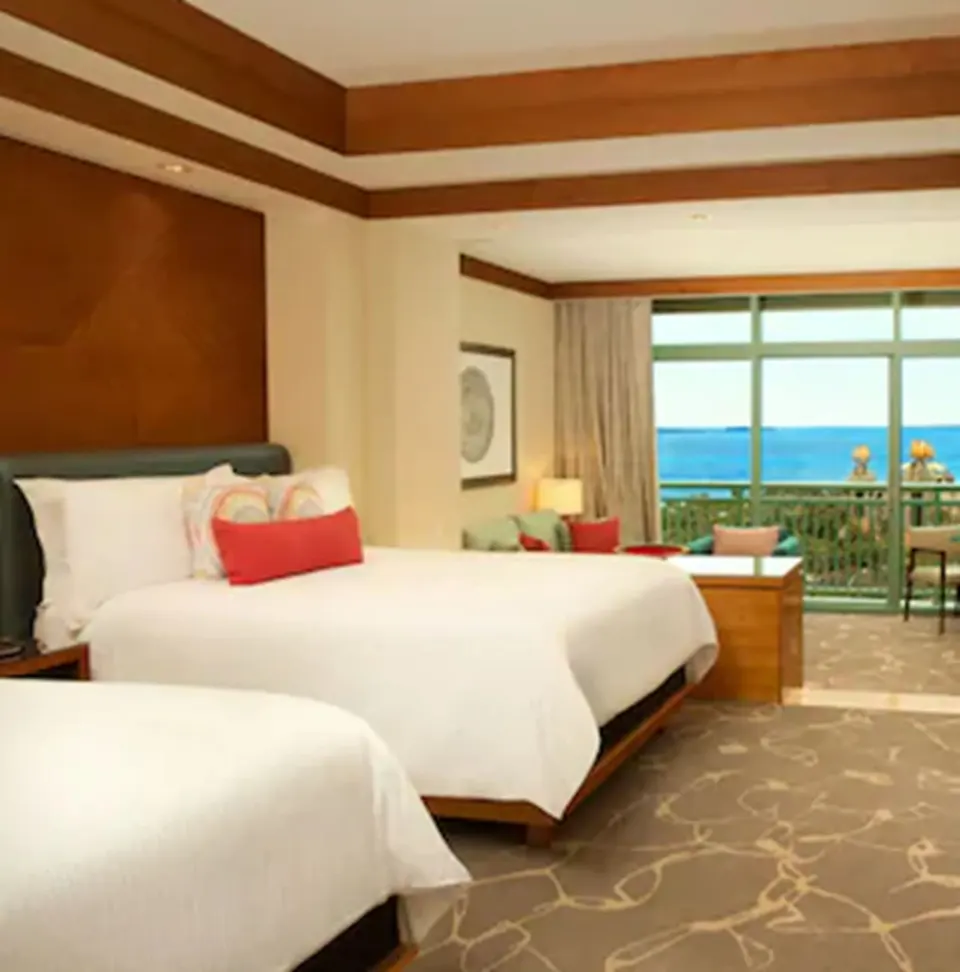 Deluxe Ocean Suite bedroom with two beds and balcony view at The Cove at Atlantis.