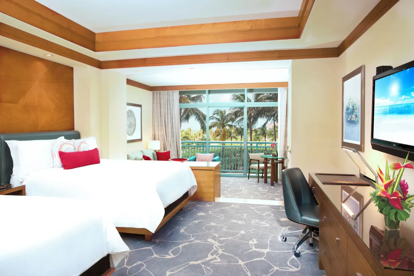 Ocean Suite bedroom with two beds and balcony seating at The Cove at Atlantis.